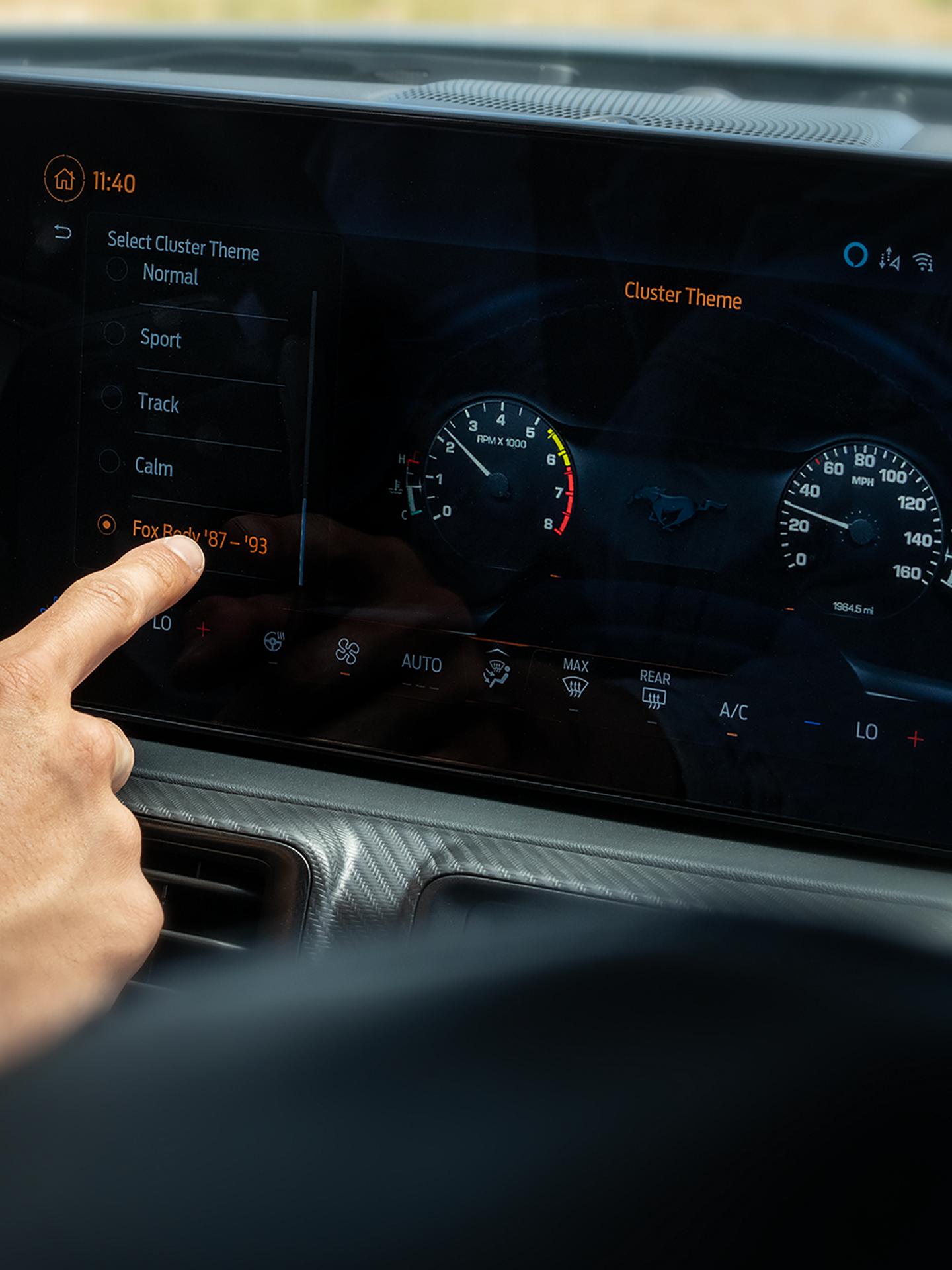 Person using the 2026 Ford Mustang® fastback display with the available magnesium-framed panoramic curved display