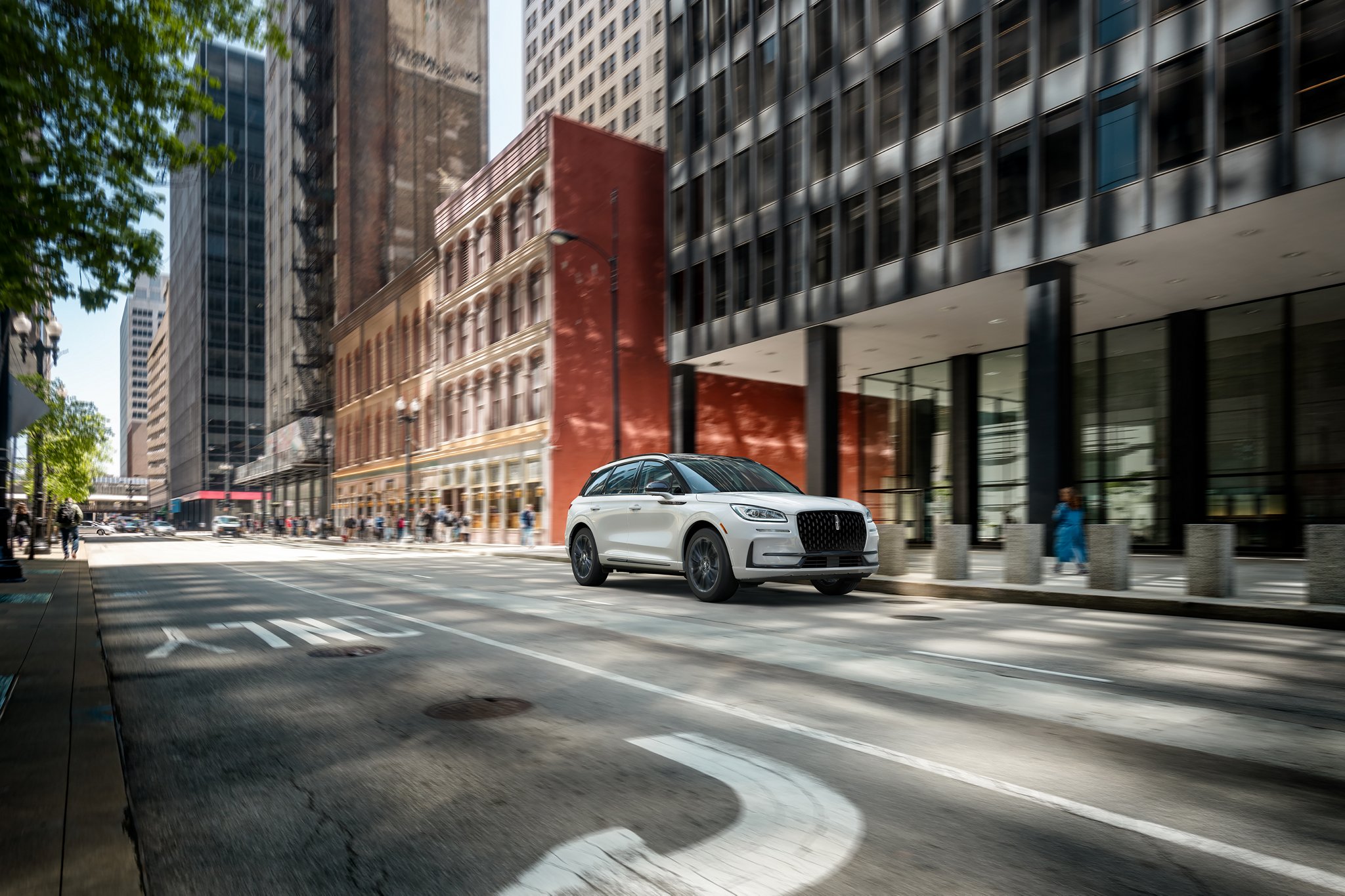 A 2025 Lincoln Corsair® Reserve model with the Available Jet Appearance Package is being driven in a city setting.