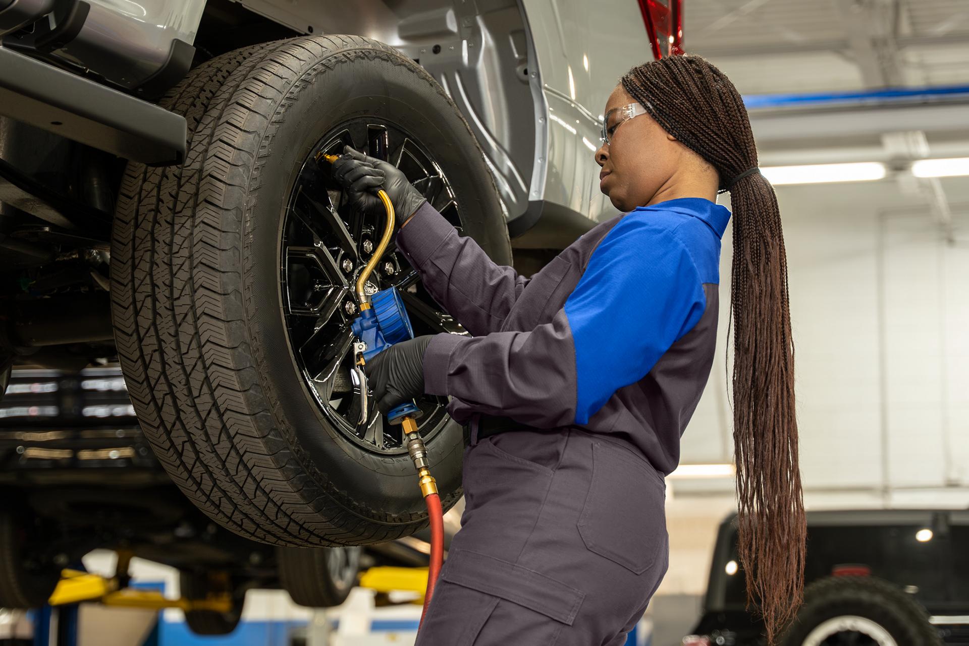 A Ford technician works on a tire