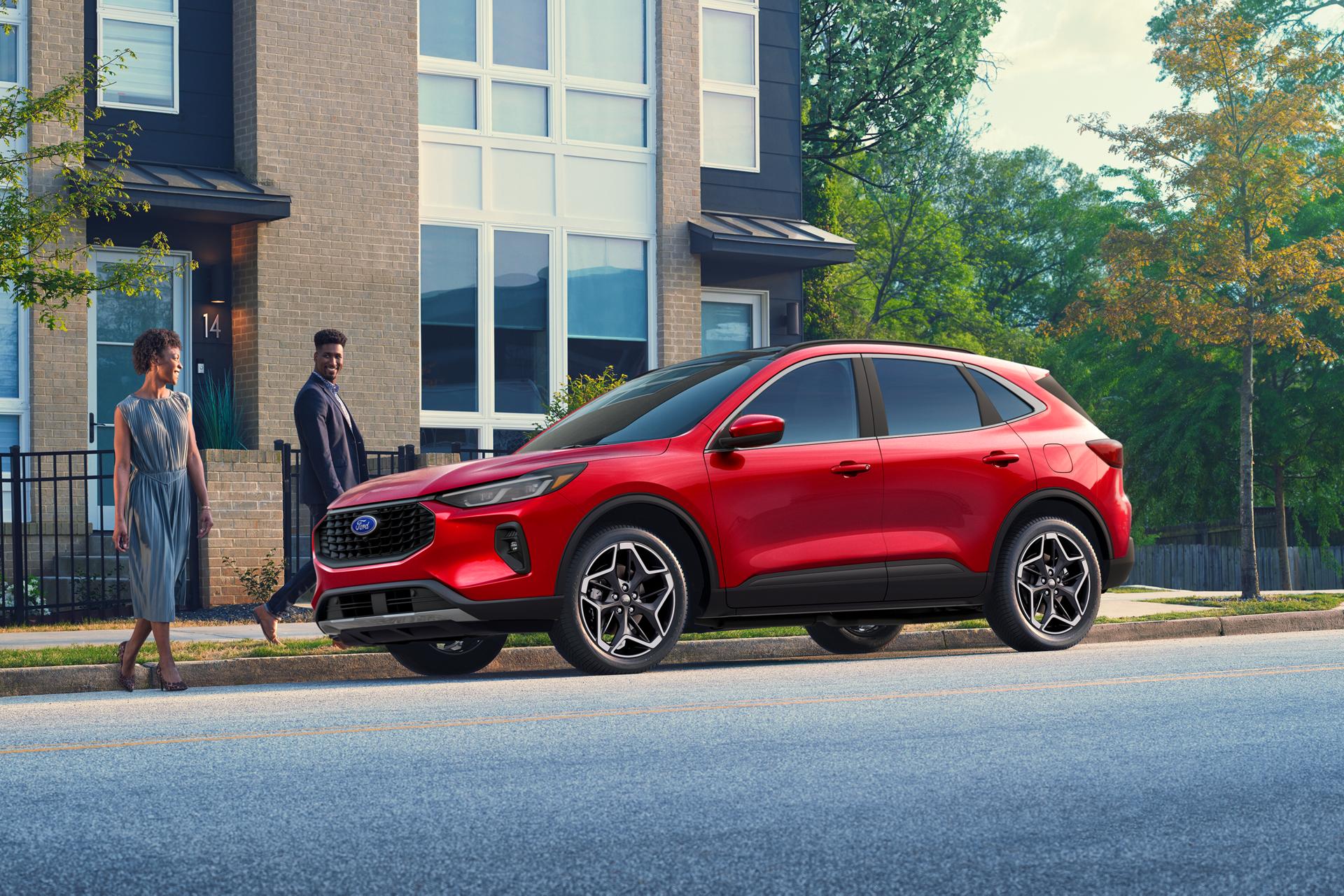 Couple walking up to a Rapid Red 2026 Ford Escape® SUV