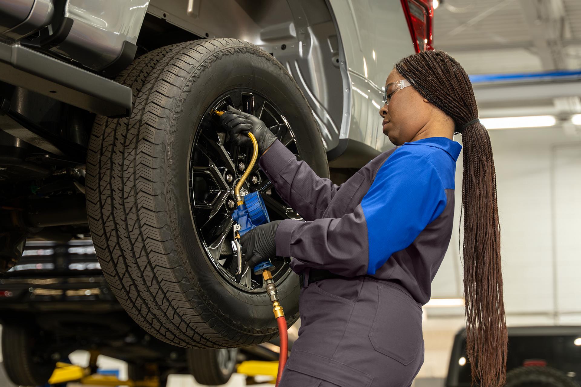 A Ford technician services the tires on a Ford vehicle