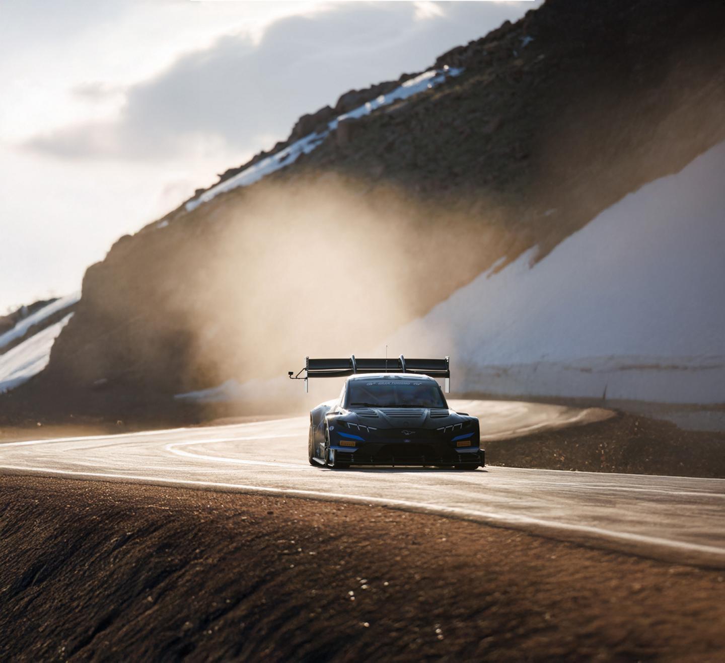 2025 Ford Super Mustang Mach-E racing on track through mountains in Pikes Peak