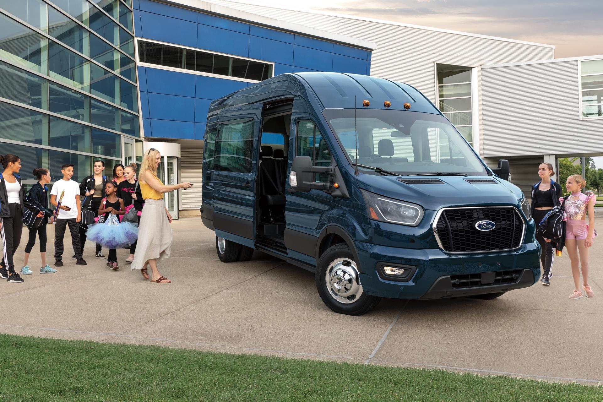 A 2026 Ford Transit® van surrounded by a group of people with the side door open