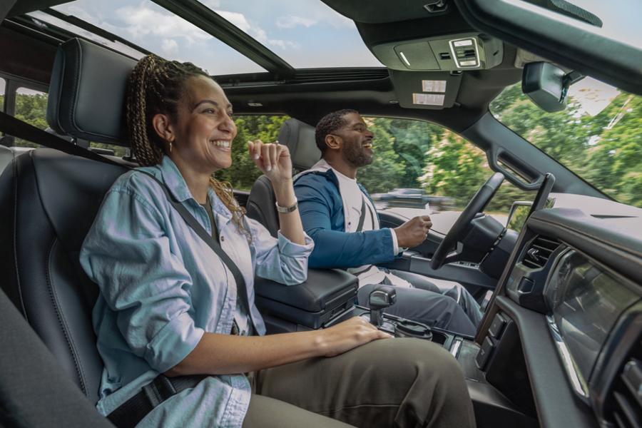 A man using available BlueCruise and a woman smiling in the passenger seat