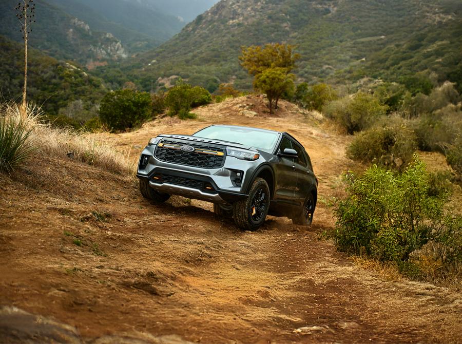 A 2026 Ford Explorer® SUV driving up a grassy hill