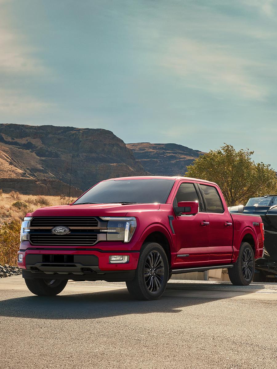 2026 Ford F-150® STX® FX4 pickup in Ruby Red Metallic pulling a boat out of the water