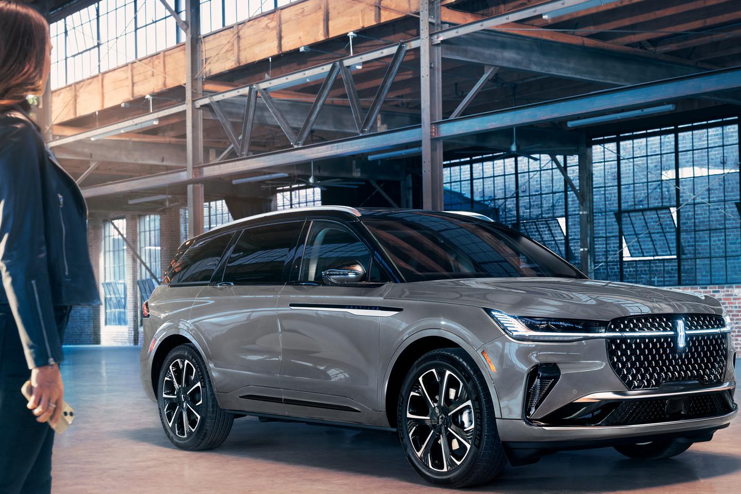 Une personne s’approche d’un Lincoln Nautilus tenant un téléphone mobile