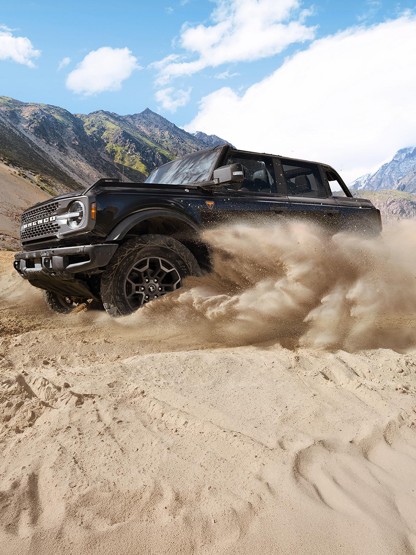 A 2026 Ford Bronco® SUV kicking up sand in a desert valley