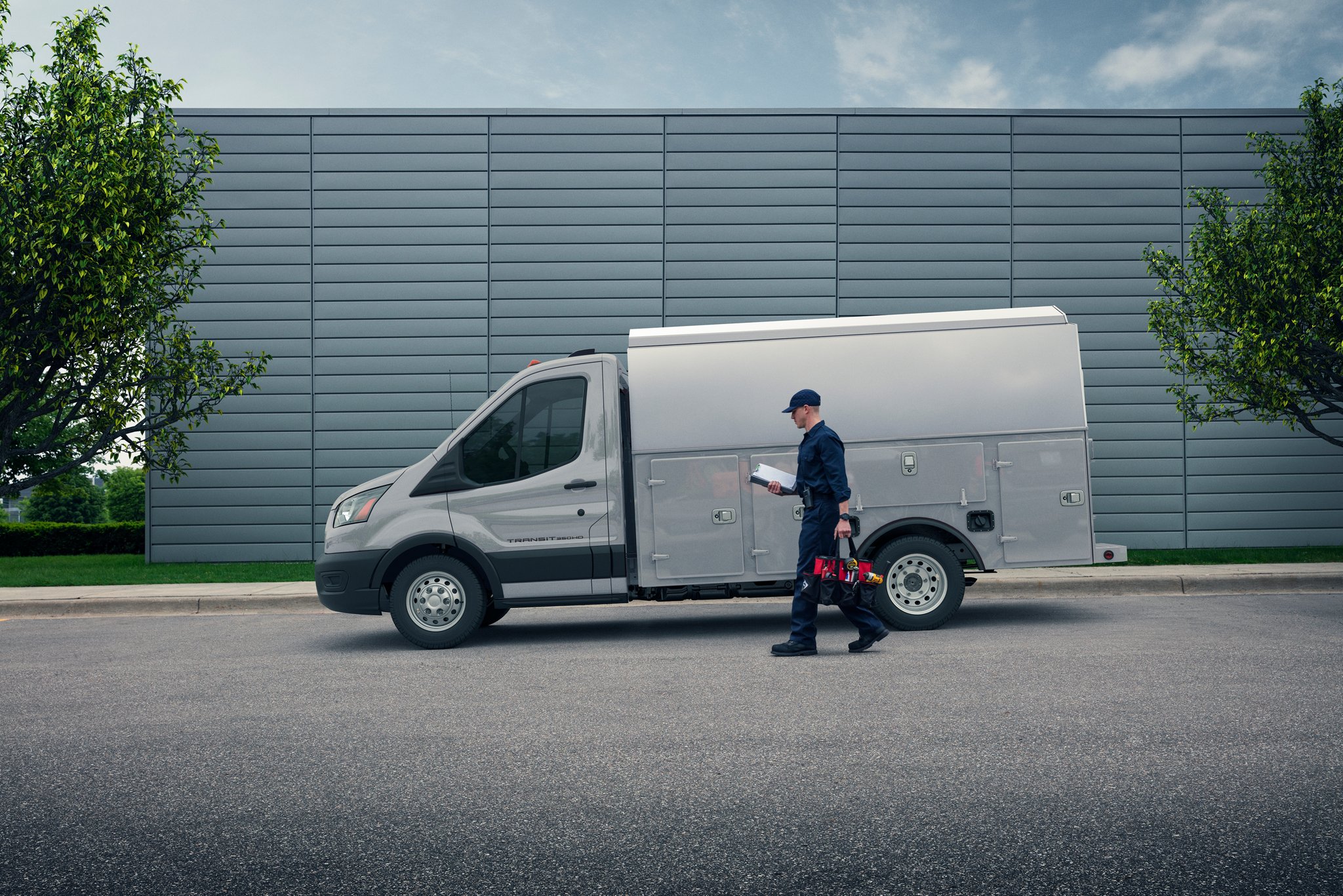 Worker walking up to a 2026 Transit® Chassis Cab parked on a street