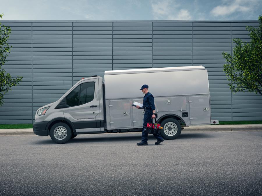 Worker walking up to a 2026 Transit® Chassis Cab parked on a street