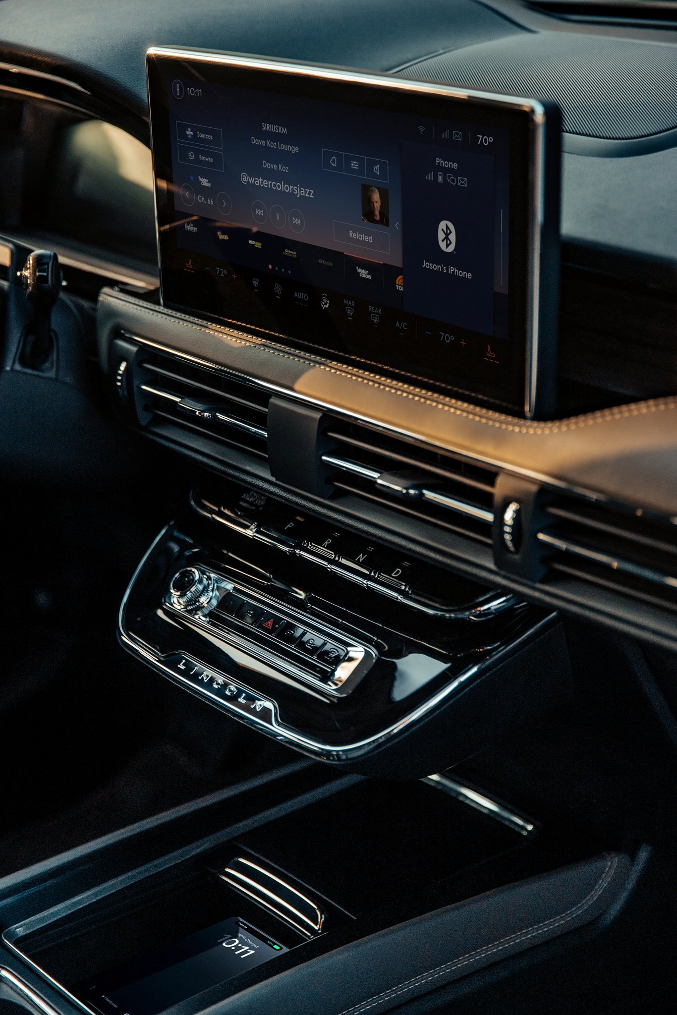 A mobile phone rests on the available wireless charging pad inside a 2025 Lincoln Corsair SUV