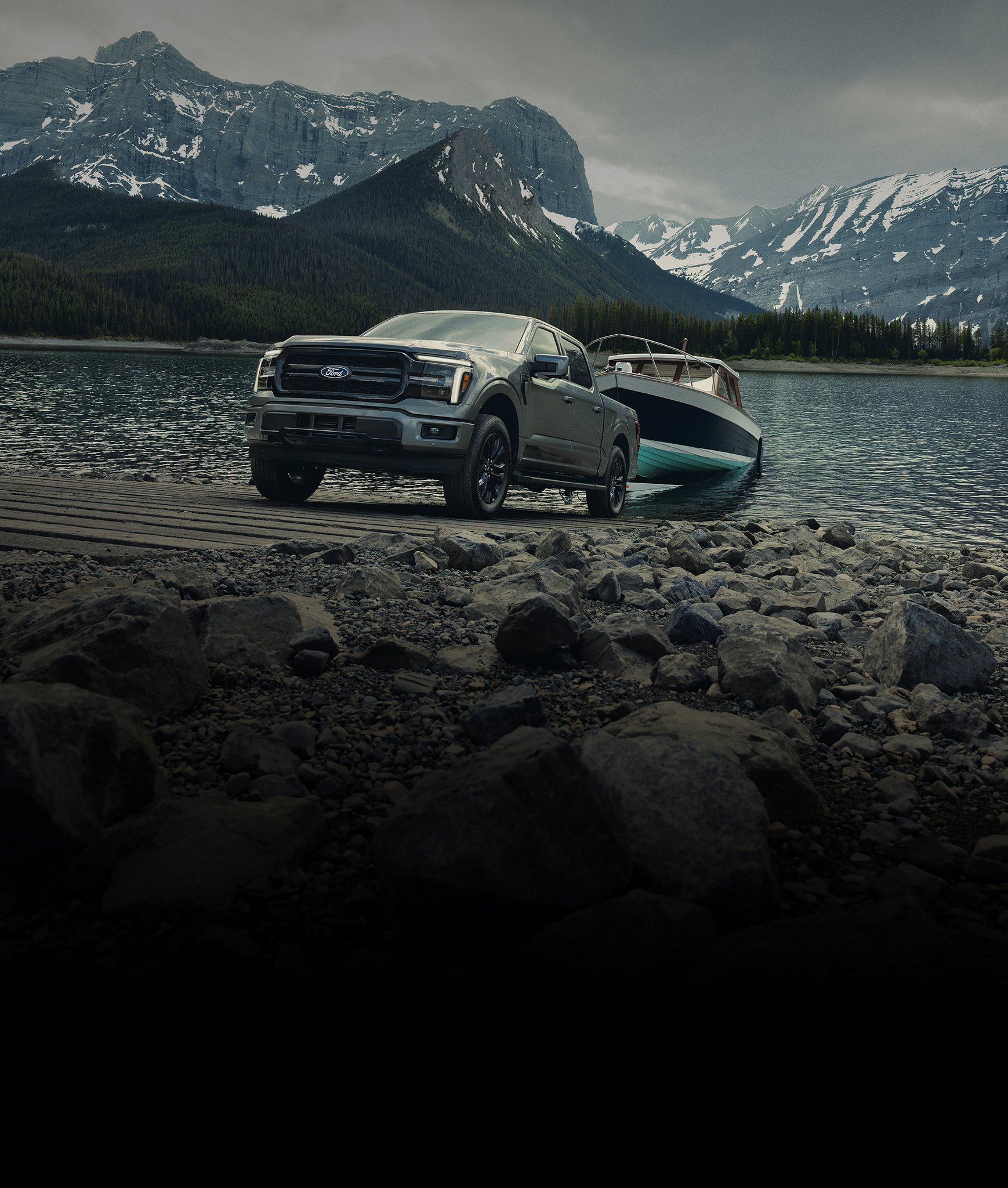 2026 Ford F-150® Lariat® with the FX4® Off-Road Package backing a boat into the water at a boat launch