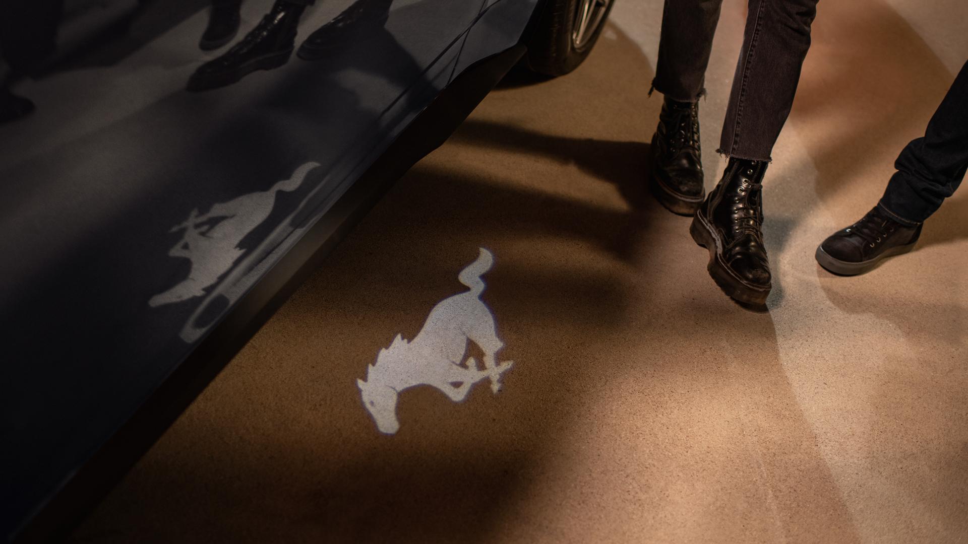 People approaching a 2026 Ford Mustang® GT Premium model with approach detection welcome exterior lighting