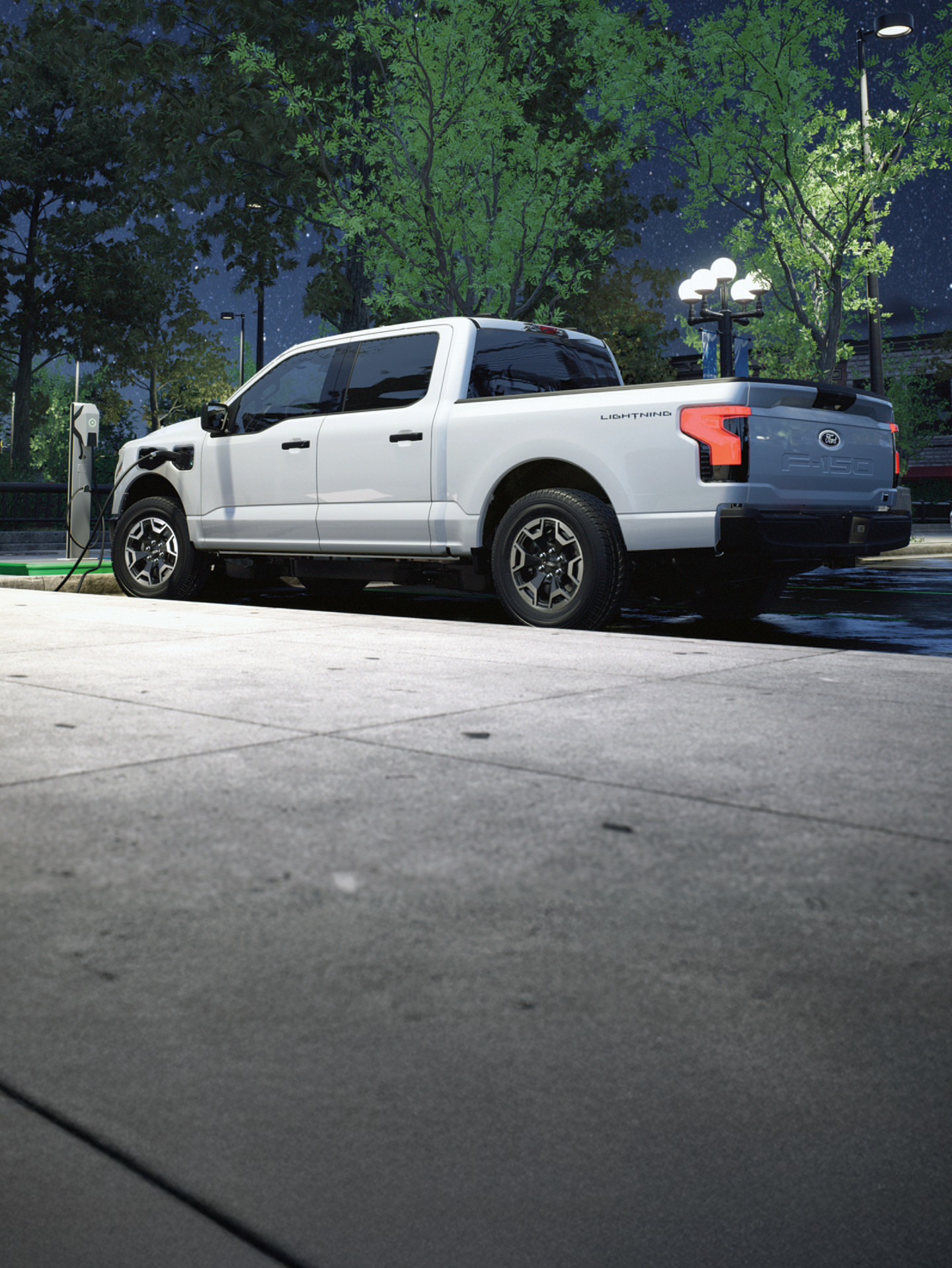 Un Ford F-150 Lightning branché à une borne de recharge publique.