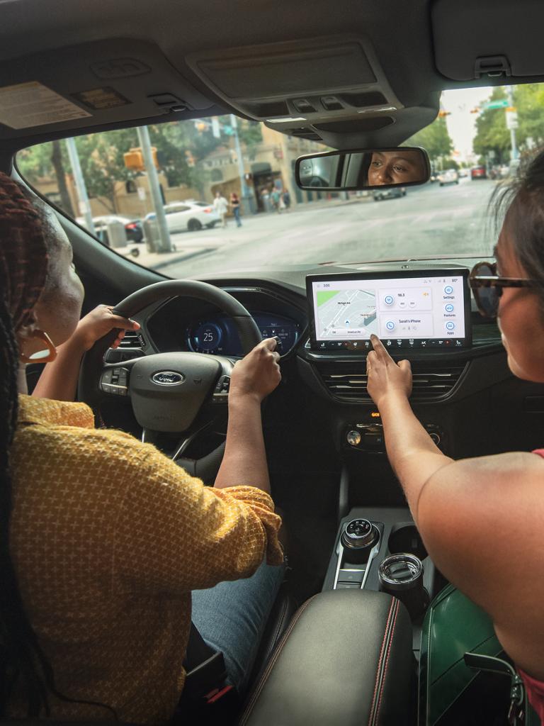 A woman driving a Ford vehicle.