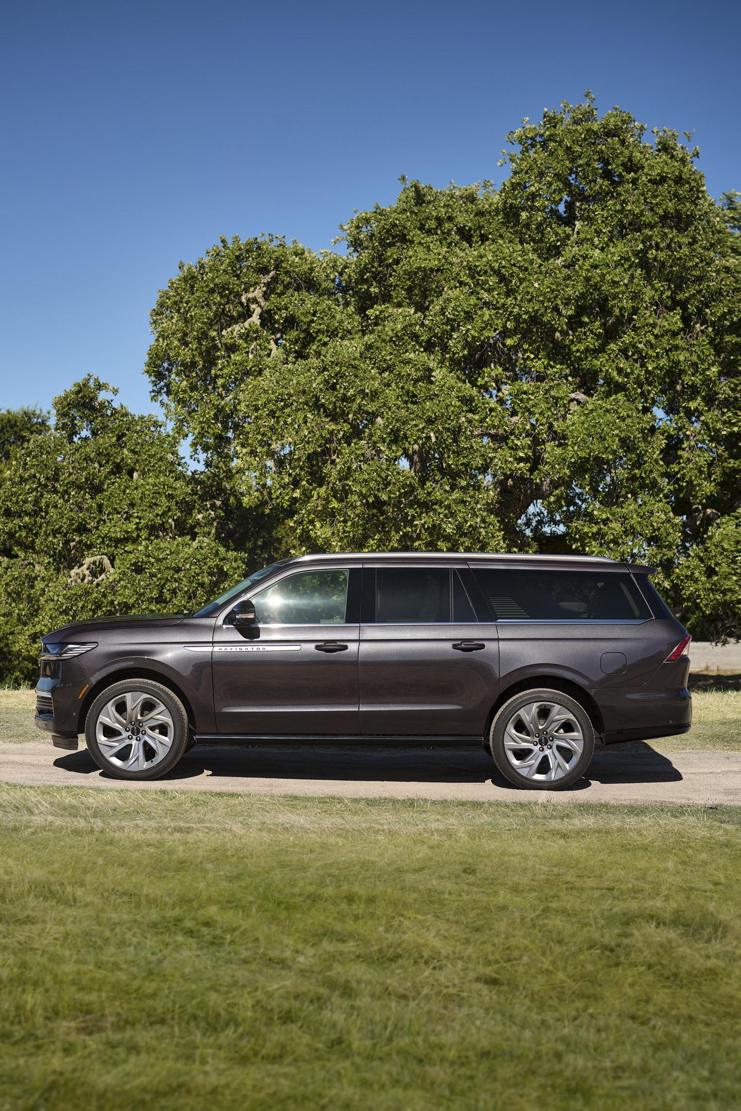 Un Lincoln Navigator® 2025 à empattement long est stationné sur une route bordée d’arbres