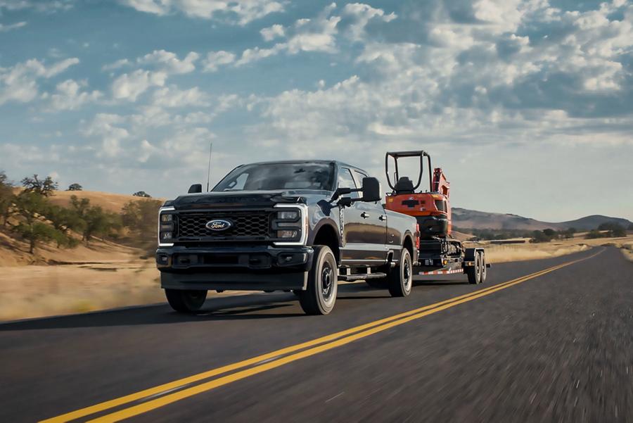 Camionnette Ford Super Duty® STX® 2025 tirant une rétrocaveuse sur une remorque