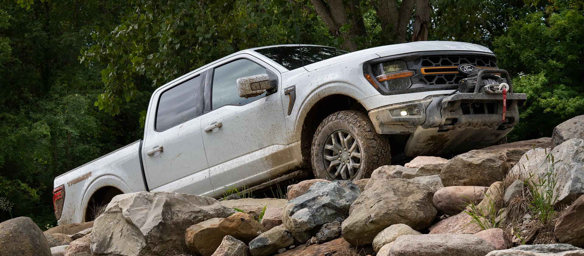 2026 Ford F-150® Tremor® pickup in Oxford White being driven up a rocky slope