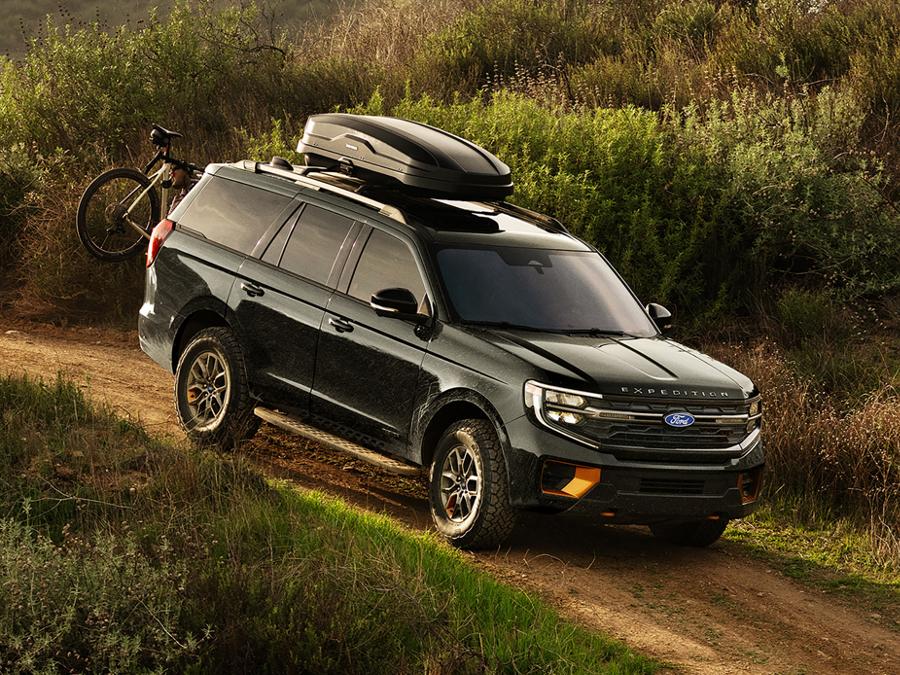 2027 Ford Expedition® Tremor® SUV with optional equipment and available Ford accessories shown being driven on a dirt road