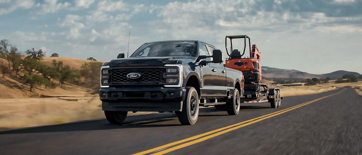 2025 Ford Super Duty® F-250® STX® pulling a tractor on a trailer
