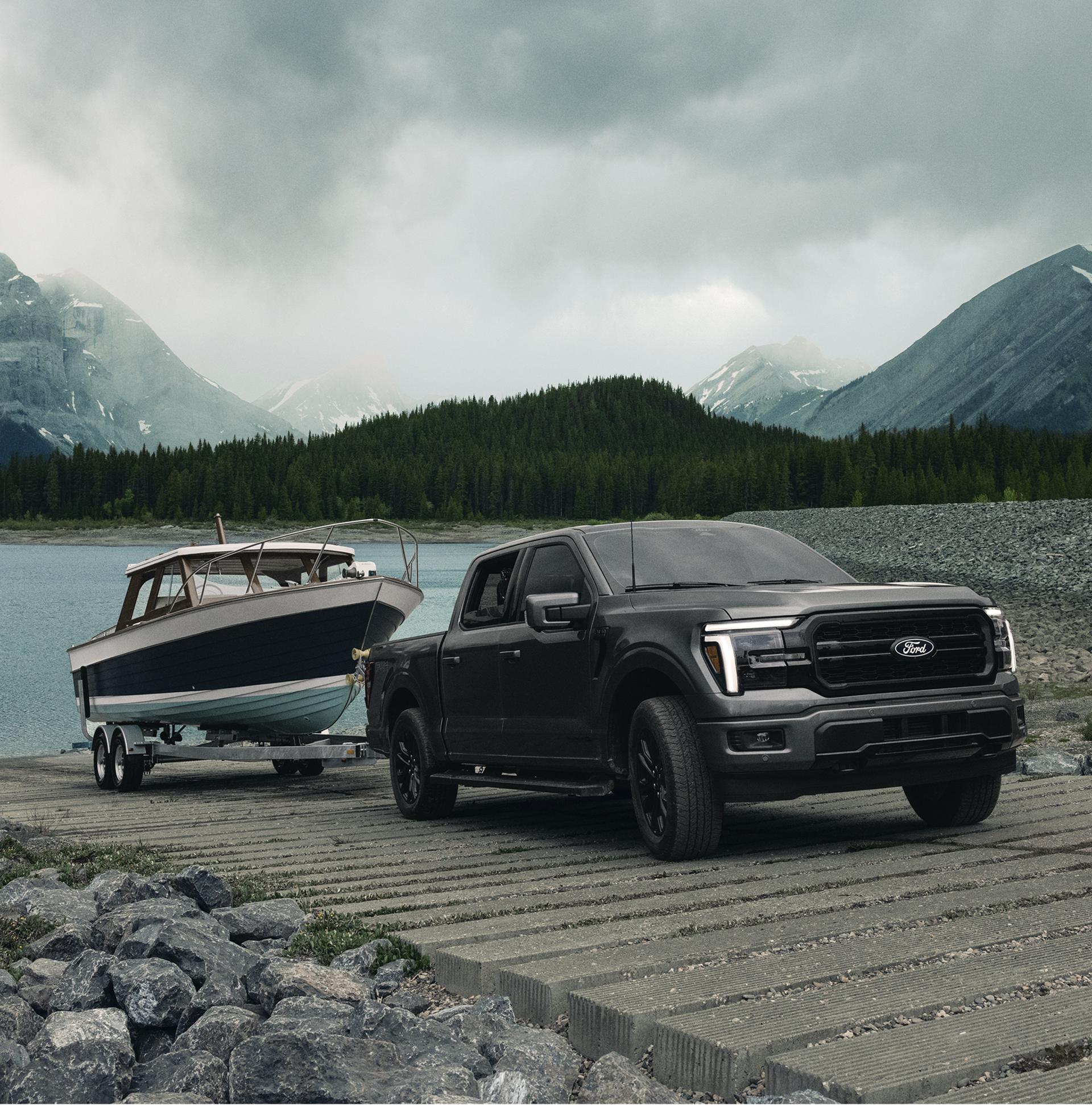 2026 Ford F-150® Lariat® with the FX4® Off-Road Package pulling a boat out of the water at a boat launch