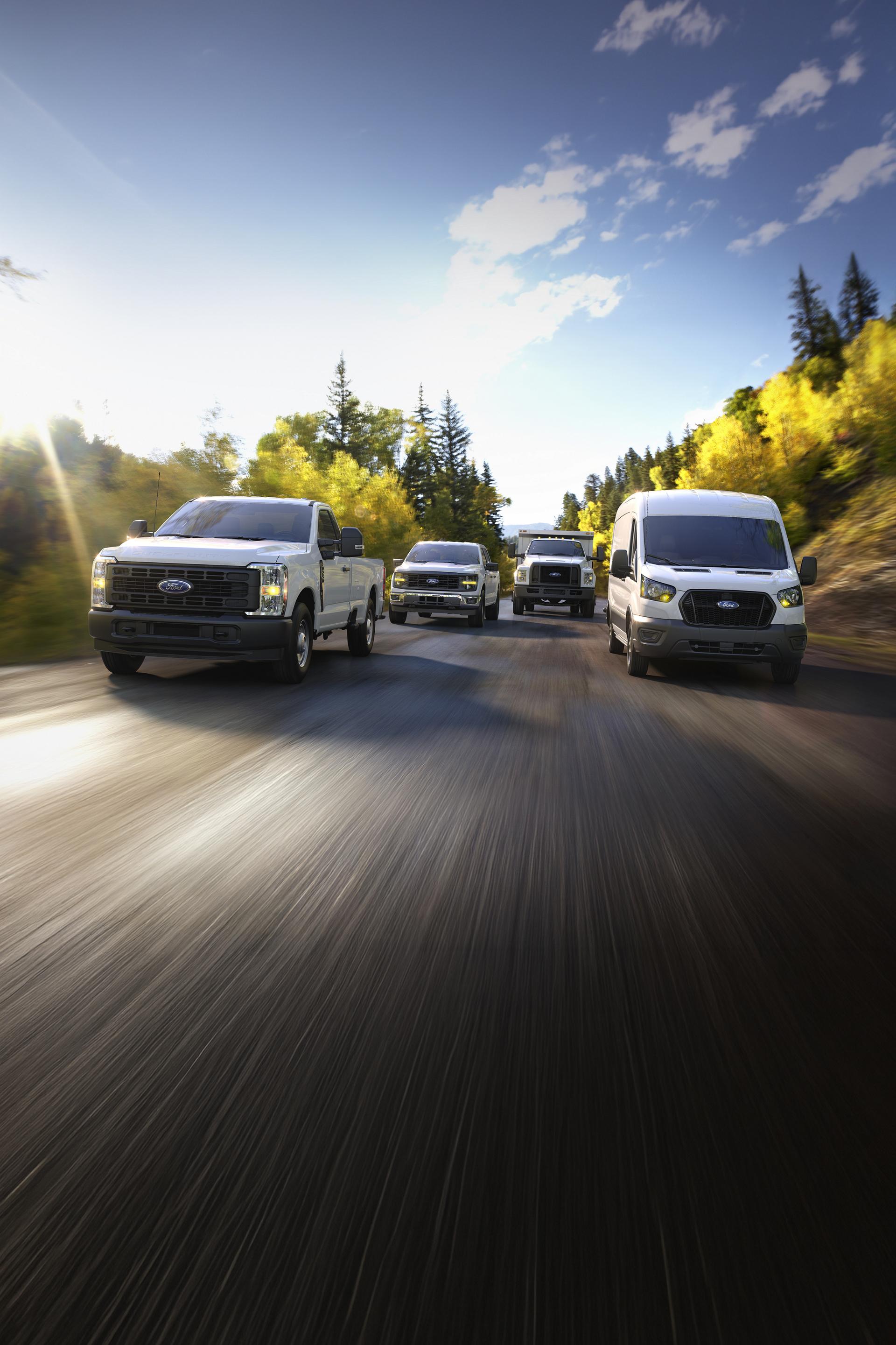 Una línea de 2026 vehículos Ford andando por un camino forestal