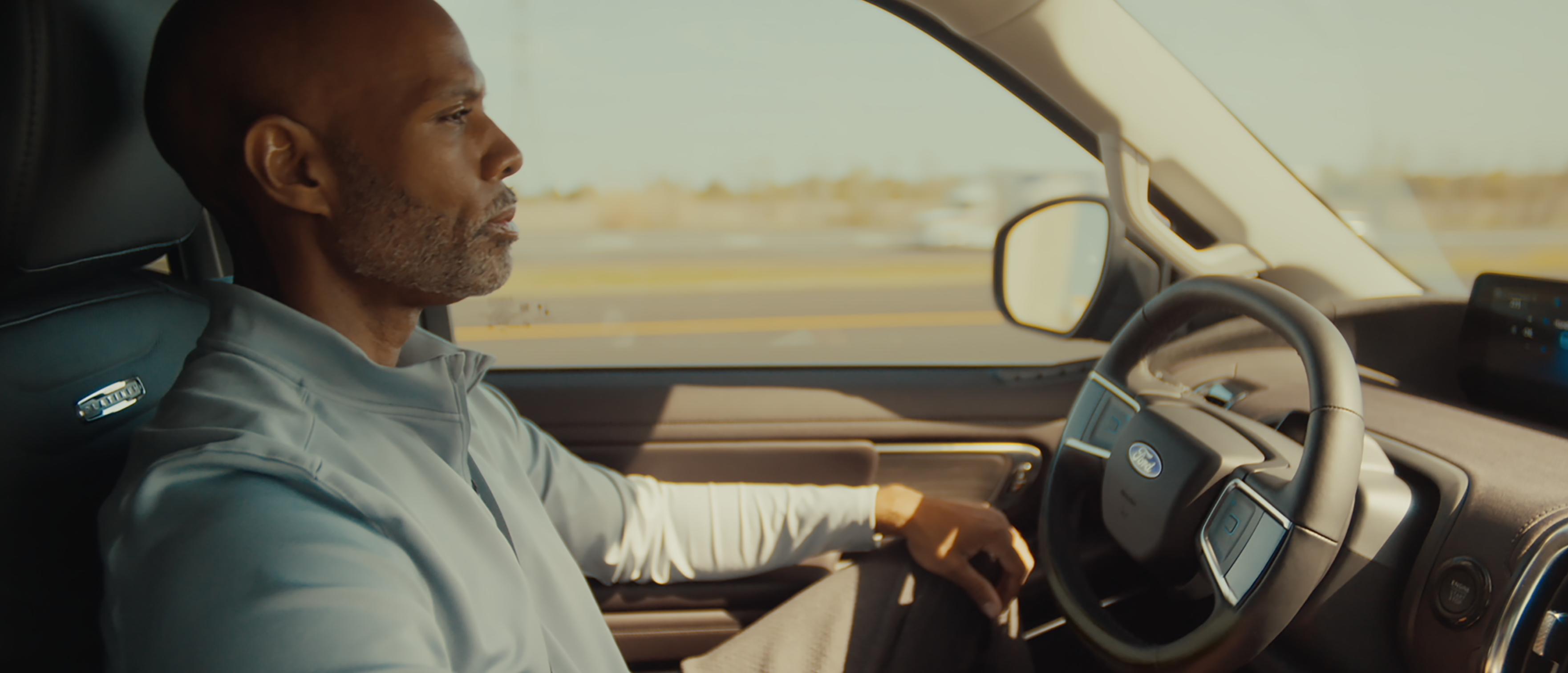 A person in a 2027 Ford Expedition® SUV driving down the highway, using the BlueCruise feature