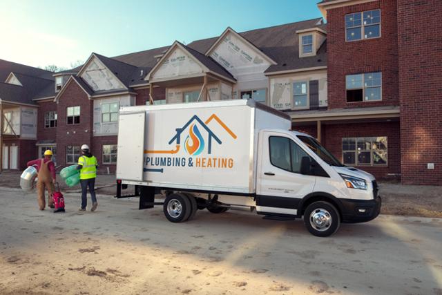 2025 Ford Transit® Chassis Cab model with box truck upfit parked at a job site with workers nearby