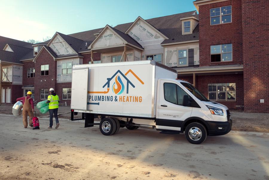 2025 Ford Transit® Chassis Cab model with box truck upfit parked at a job site with workers nearby