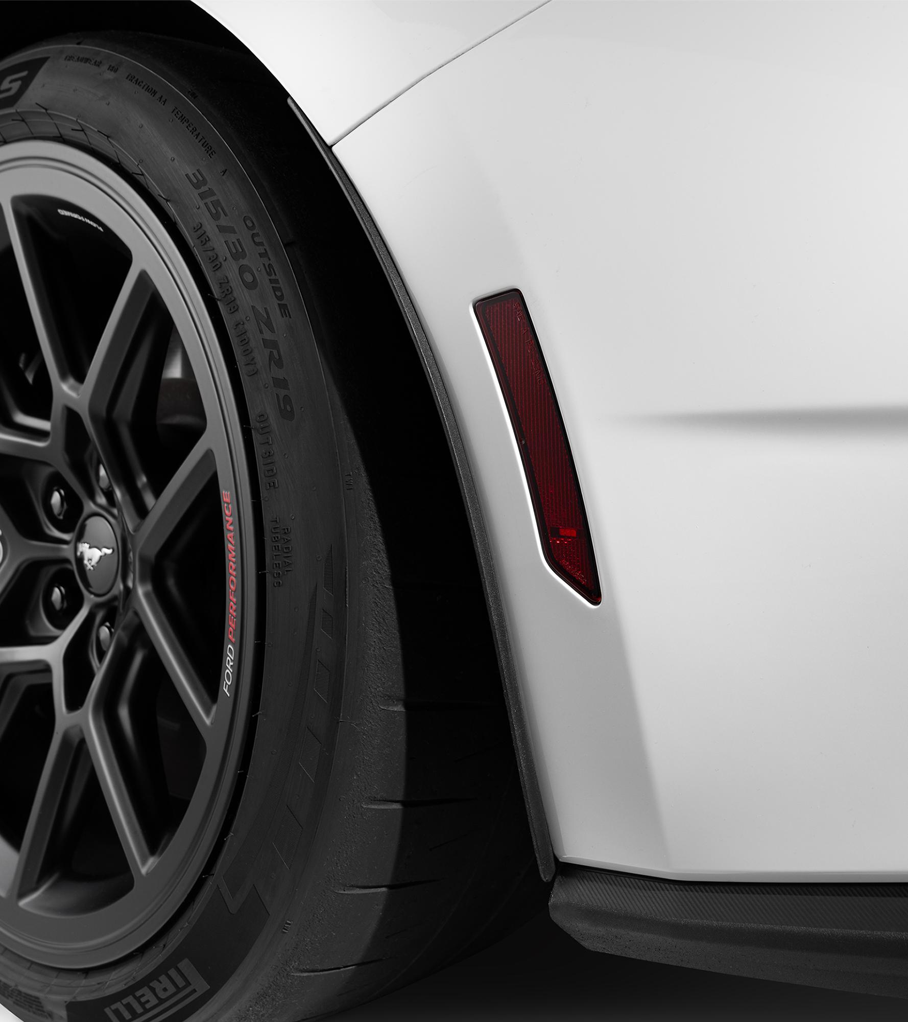 Rear wheel spat detail behind the rear tire on the white Mustang