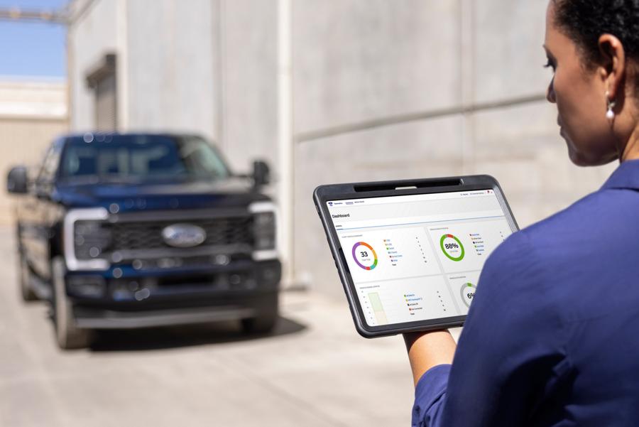 Woman looking at a tablet with a 2025 Ford Super Duty® F-250® XL STX® Appearance Package model in the background