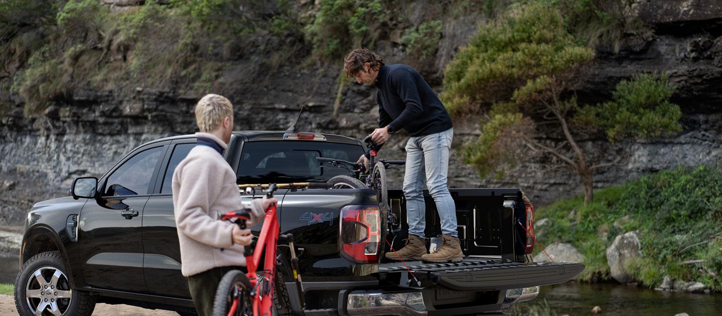 Two people loading bicycles into their 2026 Ford Ranger® truck bed