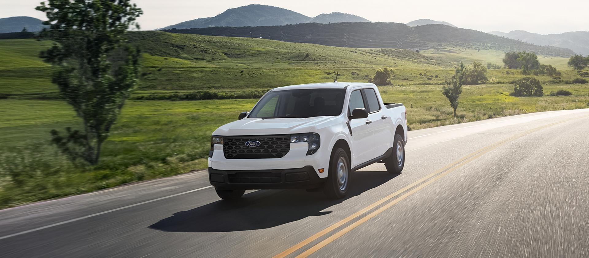 2026 Ford Maverick® pickup in Oxford White being driven on a country highway