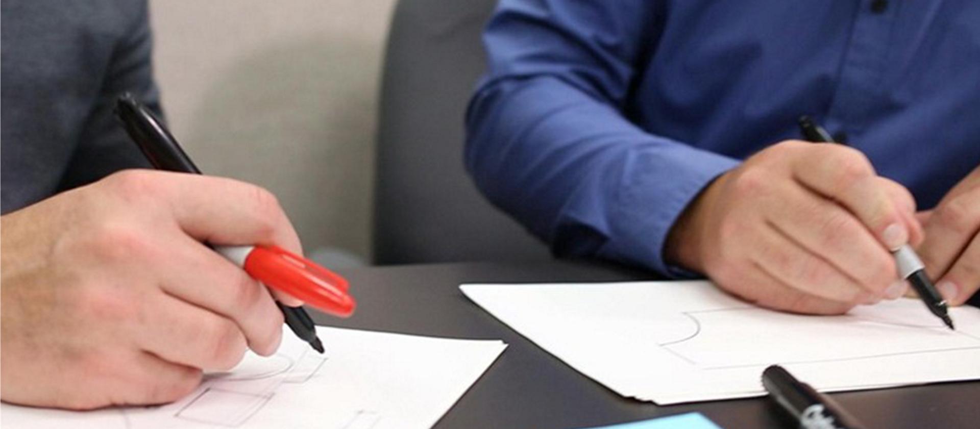 Employees brainstorm designs on paper