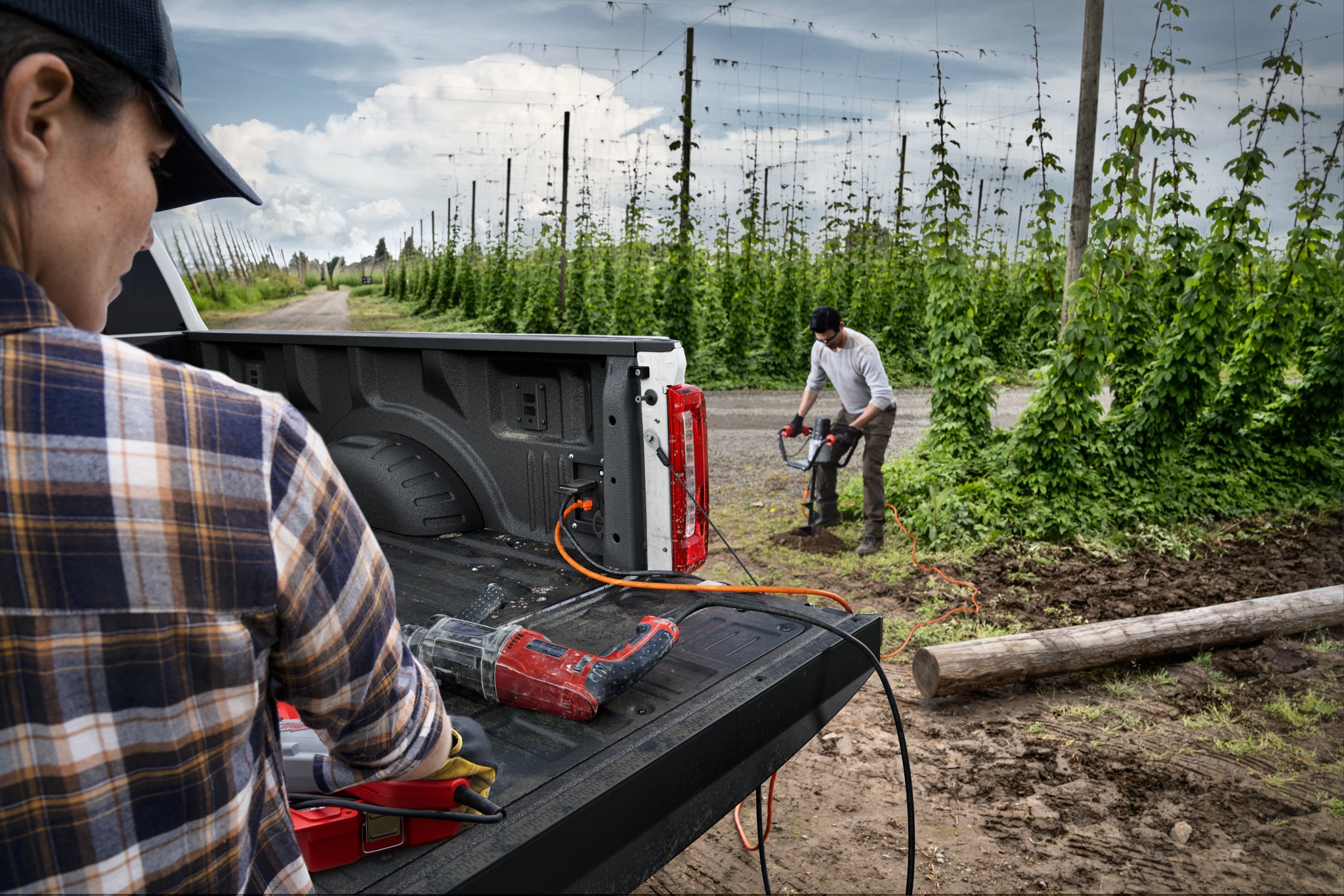 Workers using power tools plugged into Pro Power Onboard™ feature on a 2026 Ford Super Duty® XLT pickup