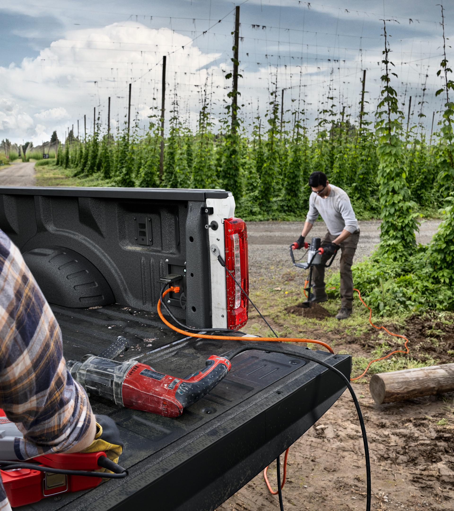Workers using power tools plugged into Pro Power Onboard™ feature on a 2026 Ford Super Duty® XLT pickup