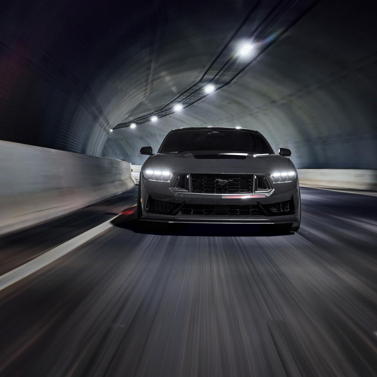Ford Mustang con luces delanteras LED andando en un túnel