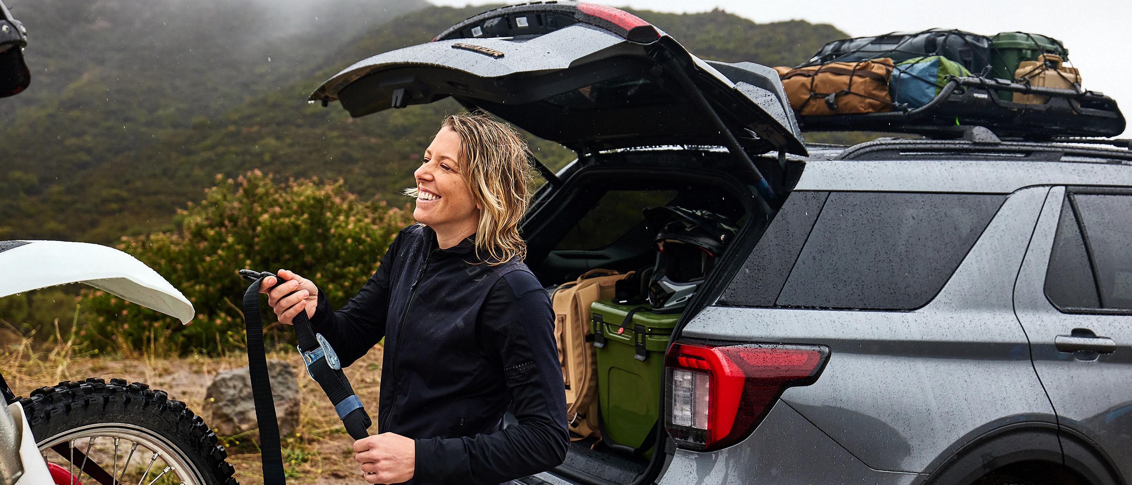 A woman unloading recreational equipment from the back of a 2026 Ford Explorer® SUV