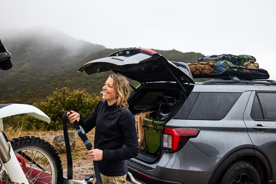 A woman unloading recreational equipment from the back of a 2026 Ford Explorer® SUV