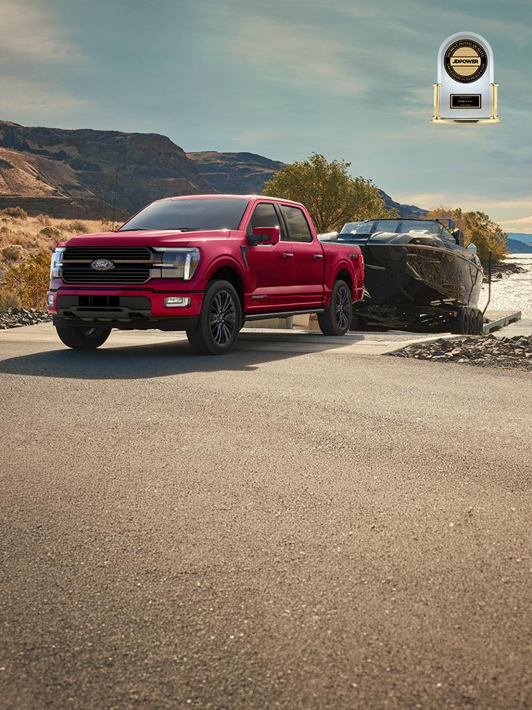 2026 Ford F-150® STX® FX4 pickup in Ruby Red Metallic pulling a boat out of the water