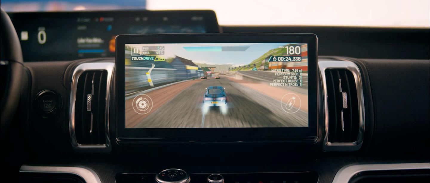 A looping video showing different couples in the front seat playing video games on the center screen while parked.