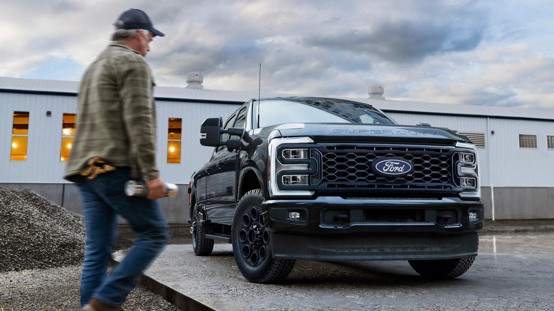 2027 Super Duty® with the Black Appearance Package parked on a cement slab with a person walking toward it.