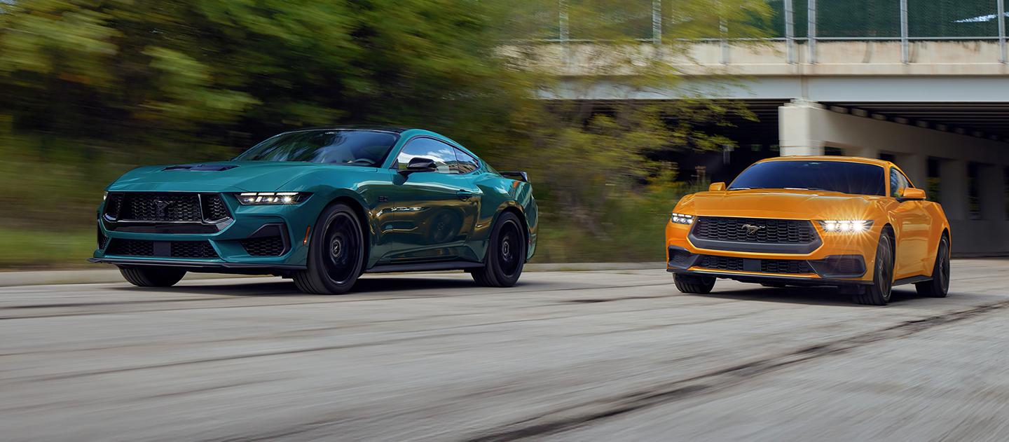 A 2026 Ford Mustang® GT fastback and a Mustang® EcoBoost® fastback being driven on a highway