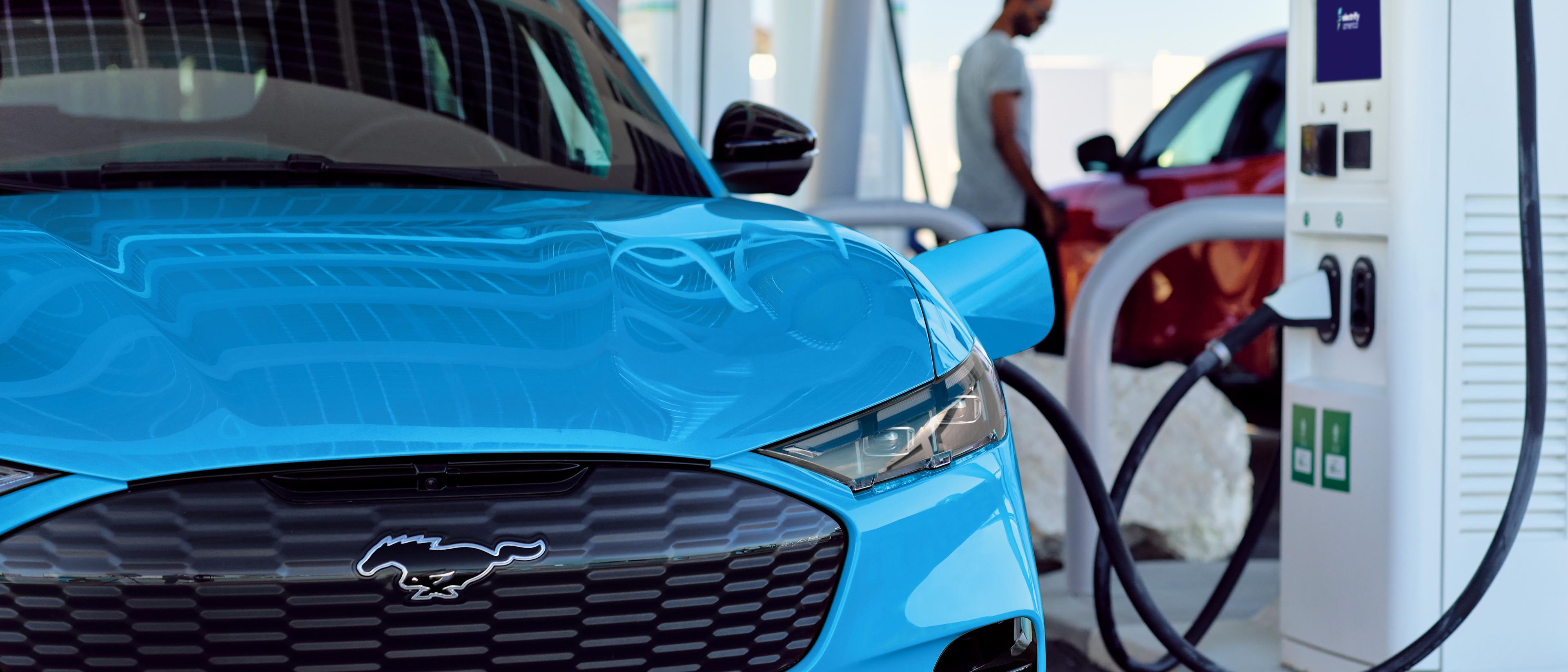 A Blue Ford Mustang Mach-E plugged into a charger