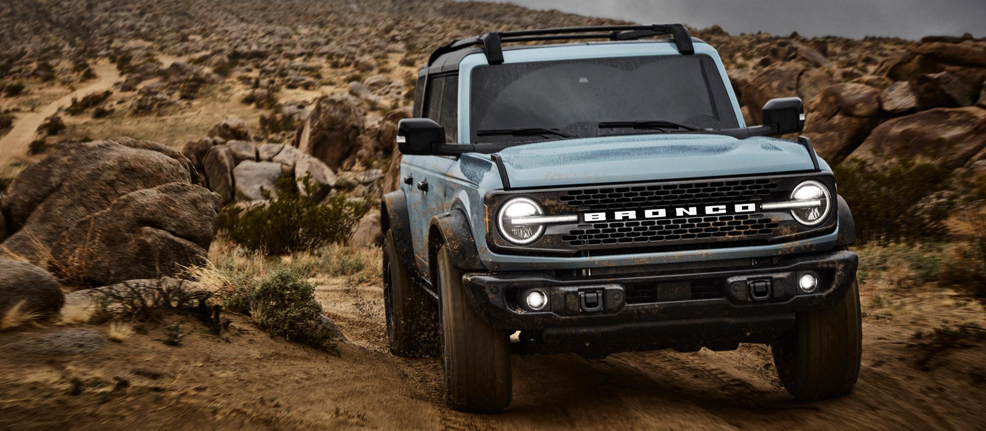 A 2025 Ford Bronco® SUV driving on a dirt trail in the high desert