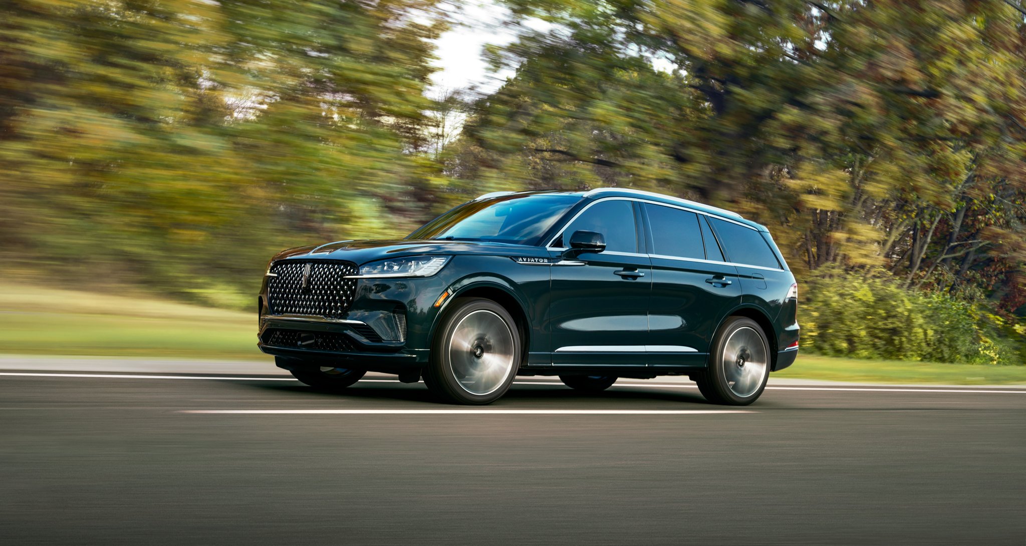 The 2025 Lincoln Aviator driving down a road.