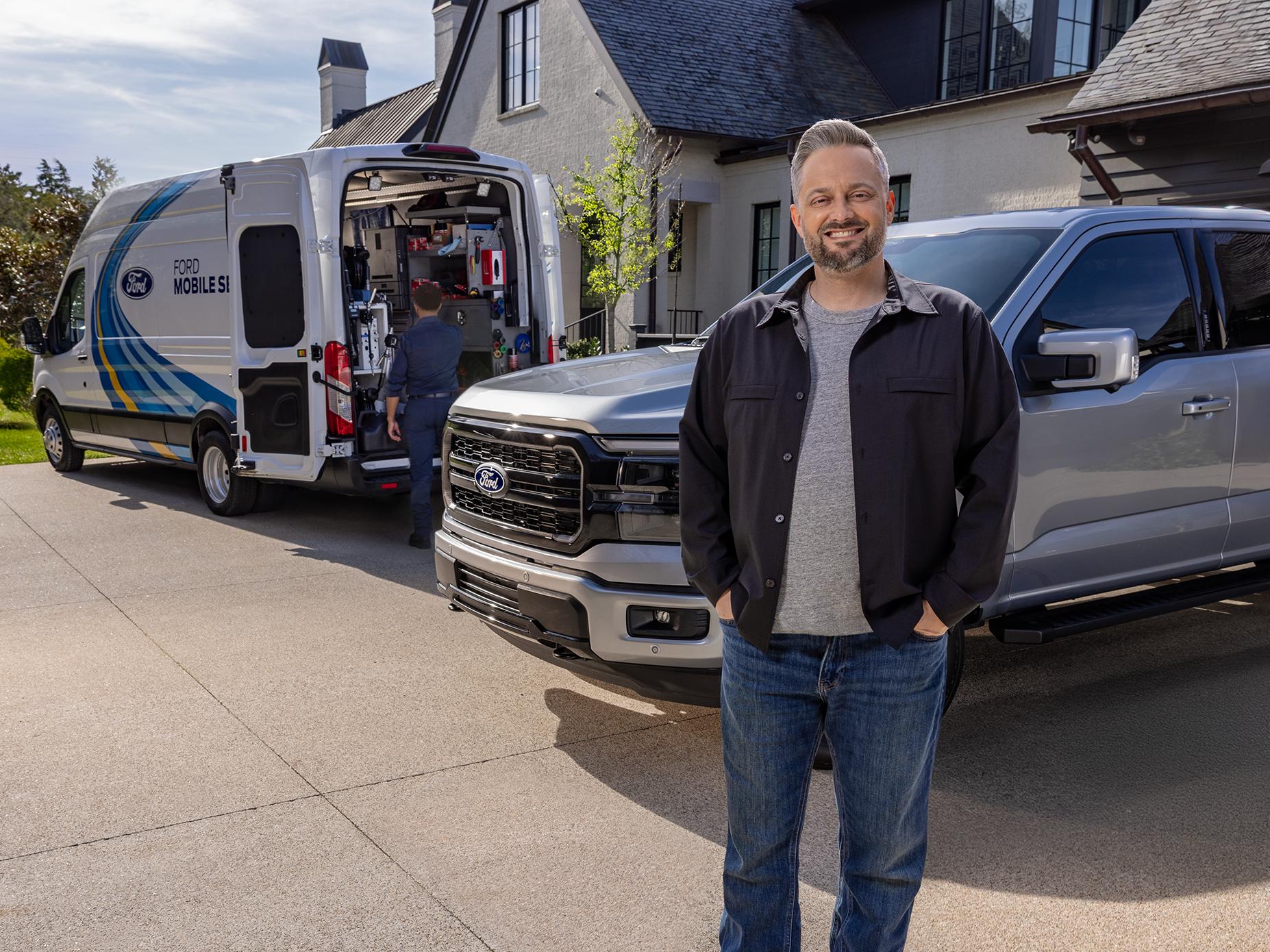Nate Bargatze stands in front of his F-150® truck as a Mobile Service tech puts tools in the van next to it