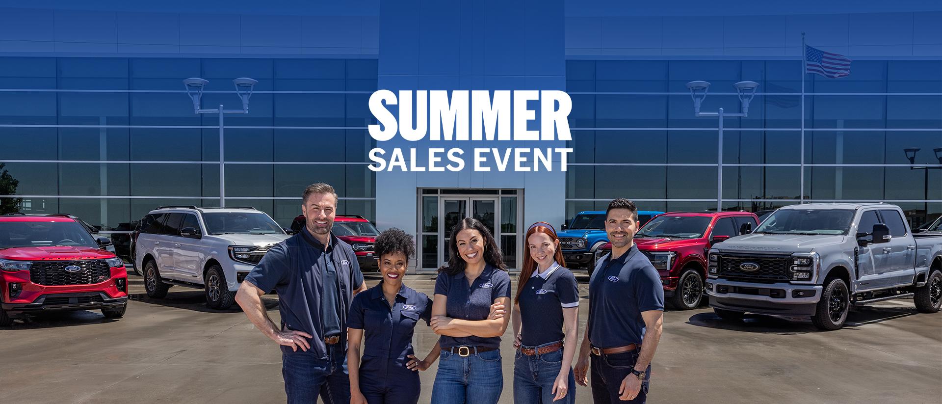 Group of employees standing in front of a Ford dealership