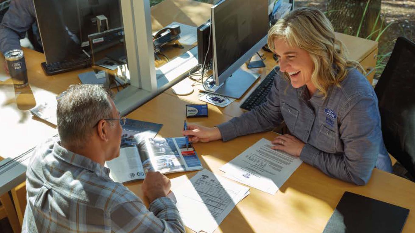 Two people at a desk going over savings options