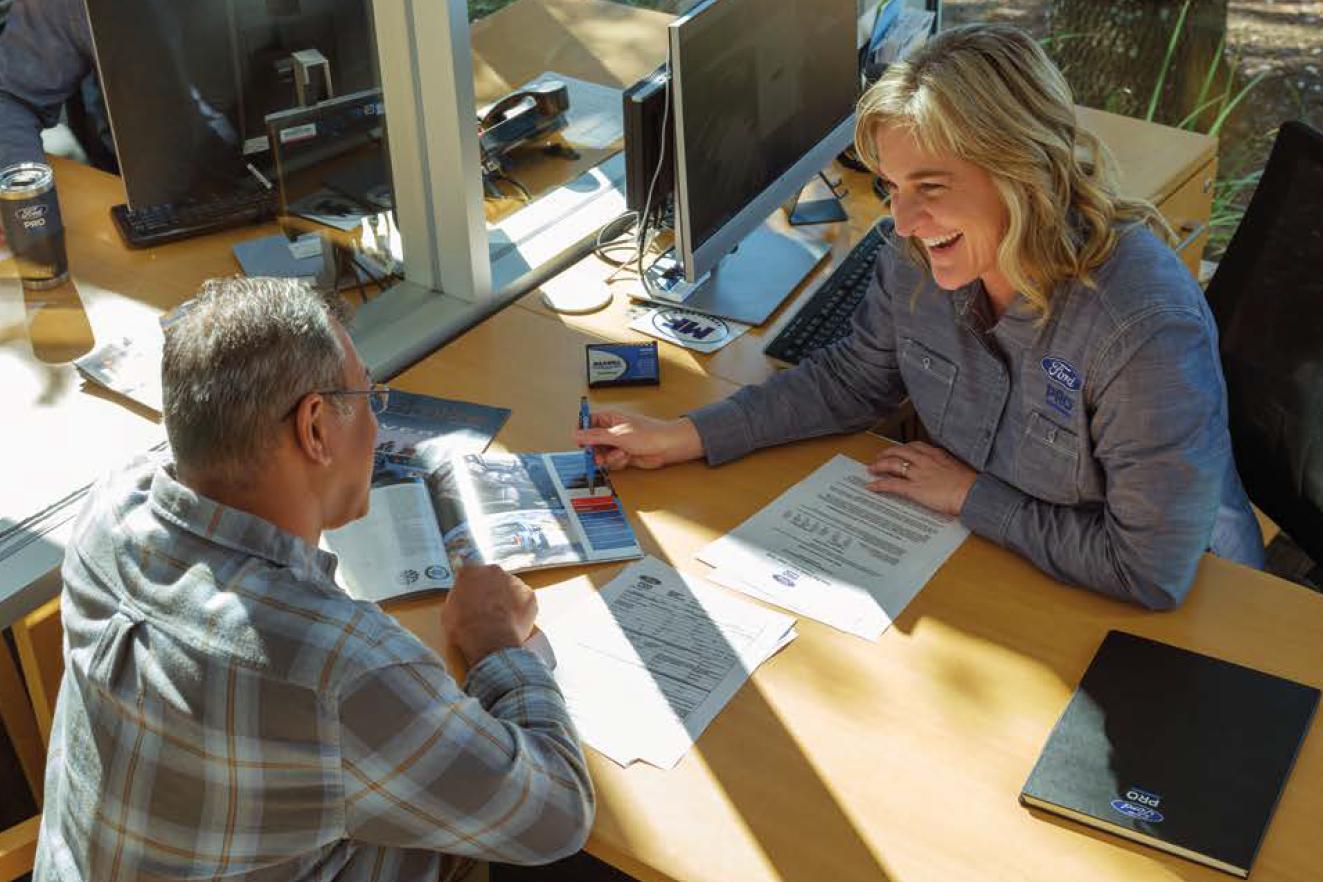 Two people at a desk going over savings options